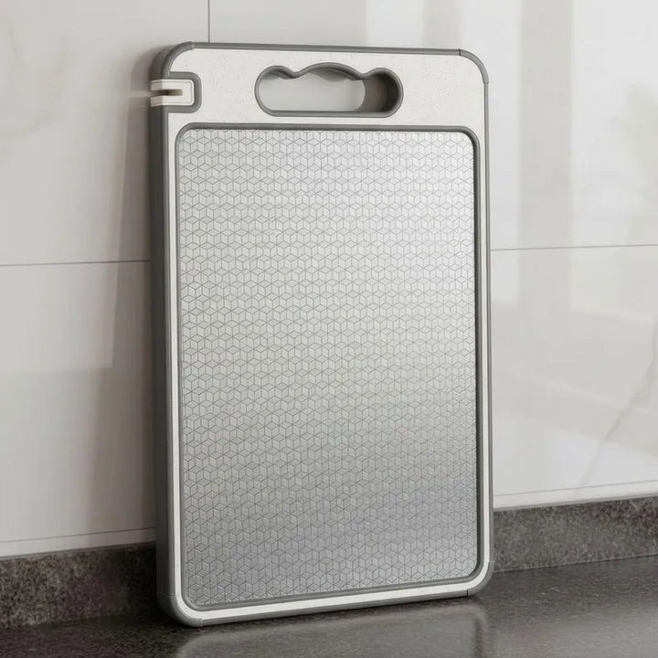 Stainless Steel Double-Sided Cutting Board - 4-in-1 Design placed on a kitchen countertop, showcasing its durable surface.