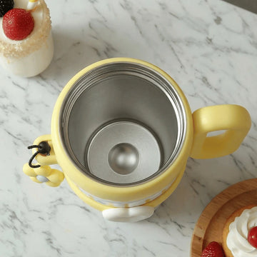 A top view of a yellow thermos mug without the lid showing the stainless steel inside on a marble surface
