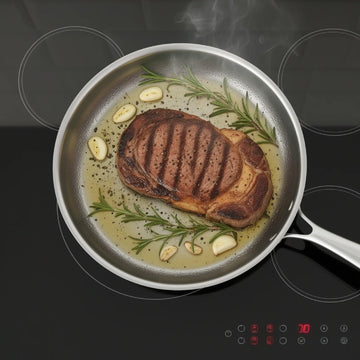 Grilled steak with garlic and rosemary in a German Stainless Steel Hammered Non-Stick Pattern frying pan on an electric stove.