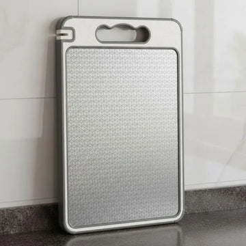 Stainless Steel Double-Sided Cutting Board - 4-in-1 Design placed on a kitchen countertop, showcasing its durable surface.
