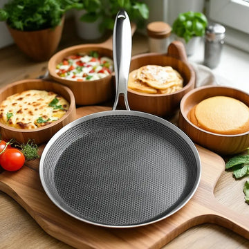 stainless steel hexclad honeycomb non-stick crepe pan 26cm on a kitchen worktop with cooking ingredients