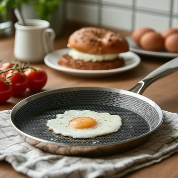 stainless steel hexclad honeycomb non-stick crepe pan 26cm on a kitchen worktop with cooking ingredients